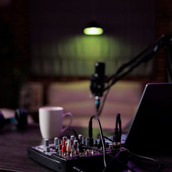 Empty desk with podcast equipment record live talking show home no people living room used online vlogging broadcasting conversation with microphone sound production 600x600
