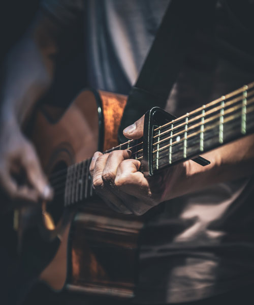 Man plays acoustic guitar closeup600x500