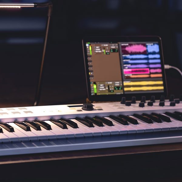 Musical keyboard tablet dark room music production 600x598